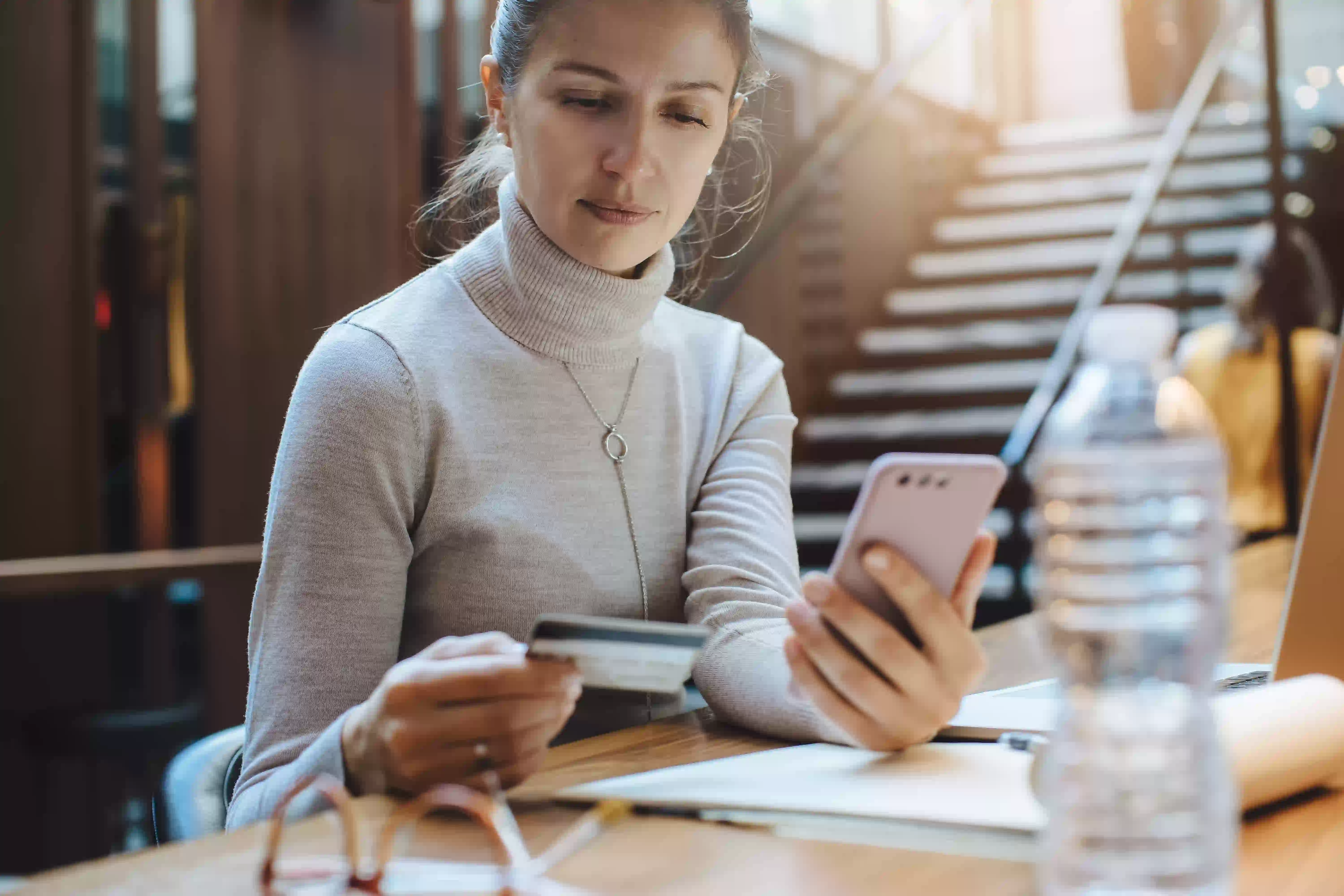 woman holding cellphone and credit card