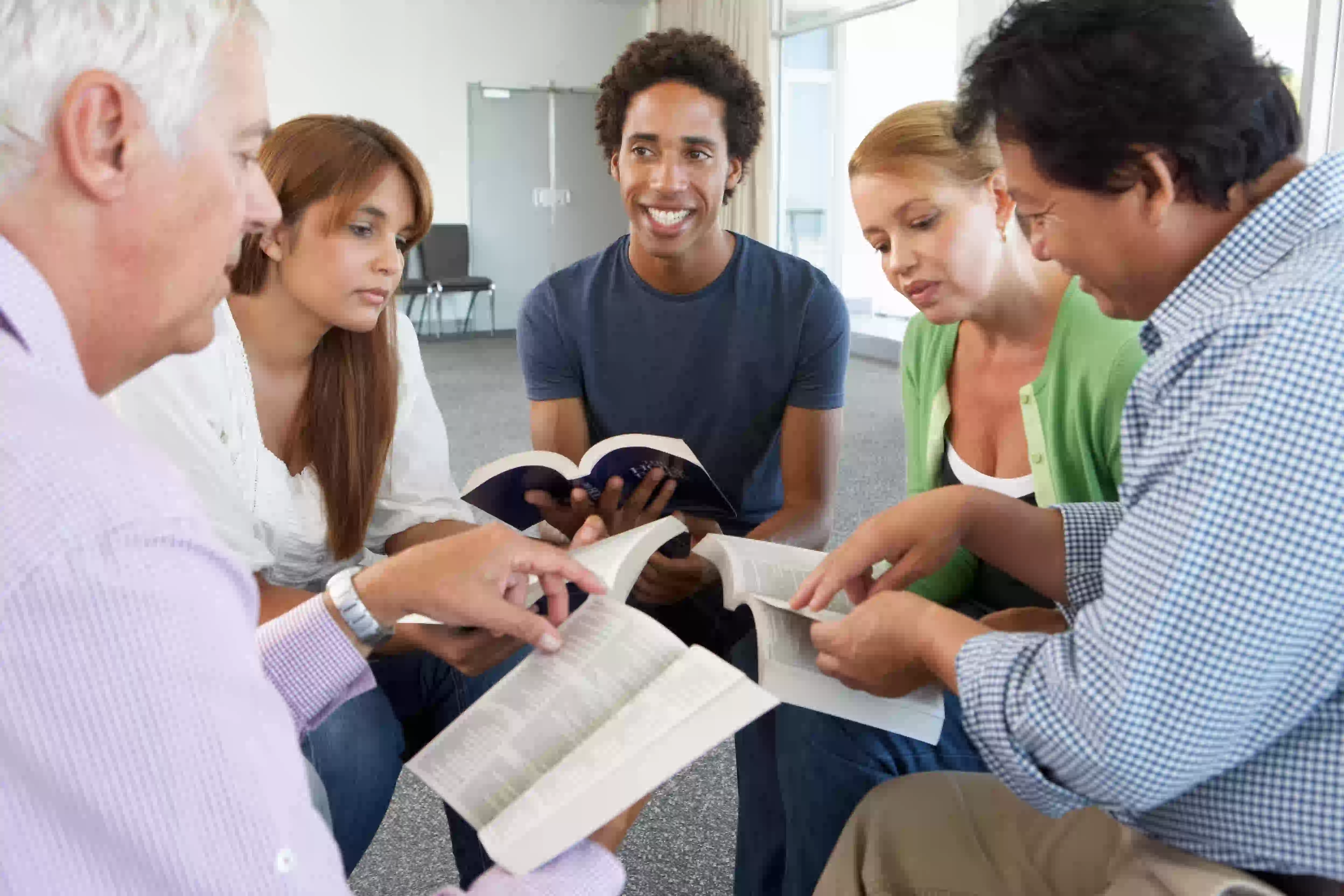 group of people holding Bibles studying