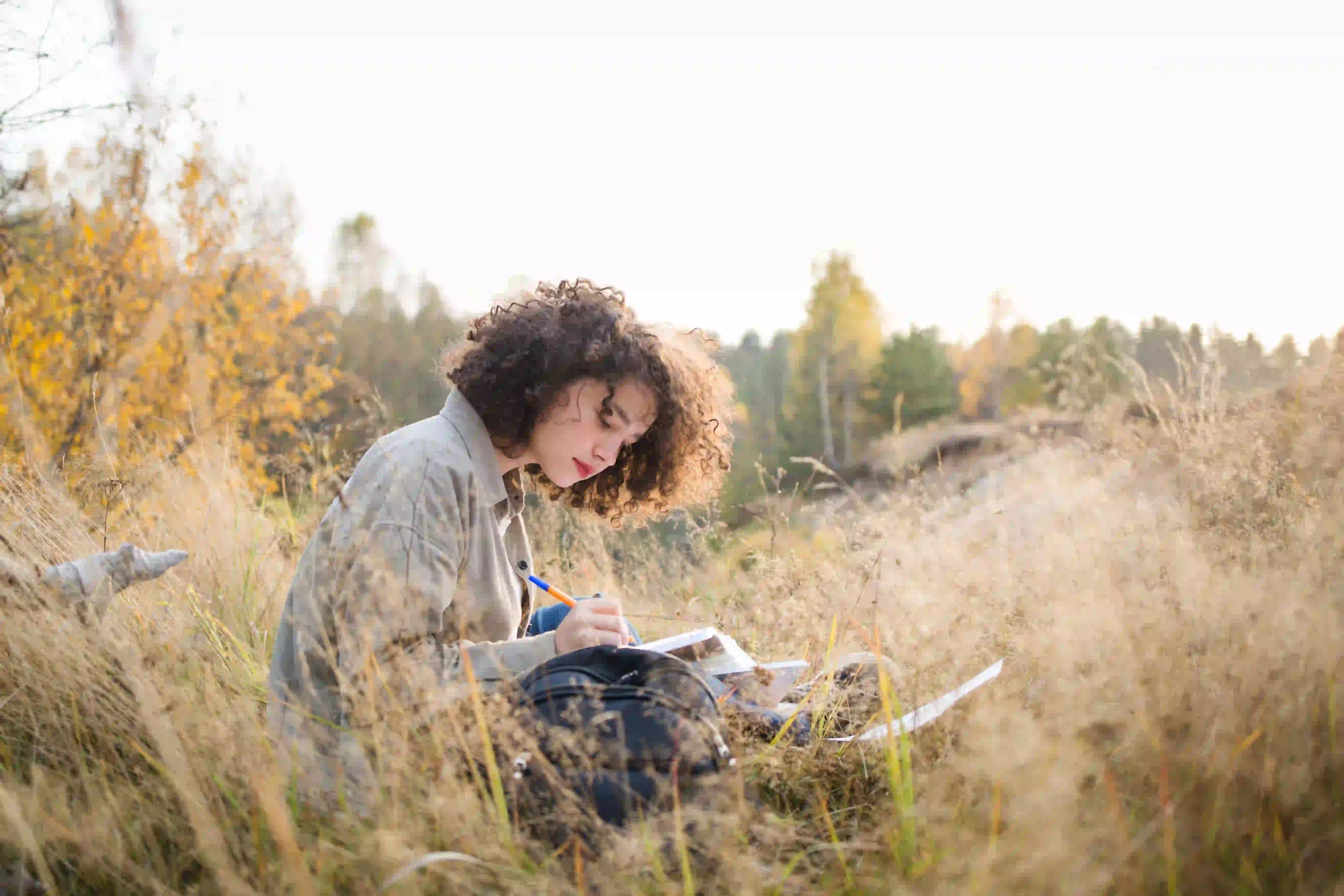 Woman reading Bible while sitting in the grass